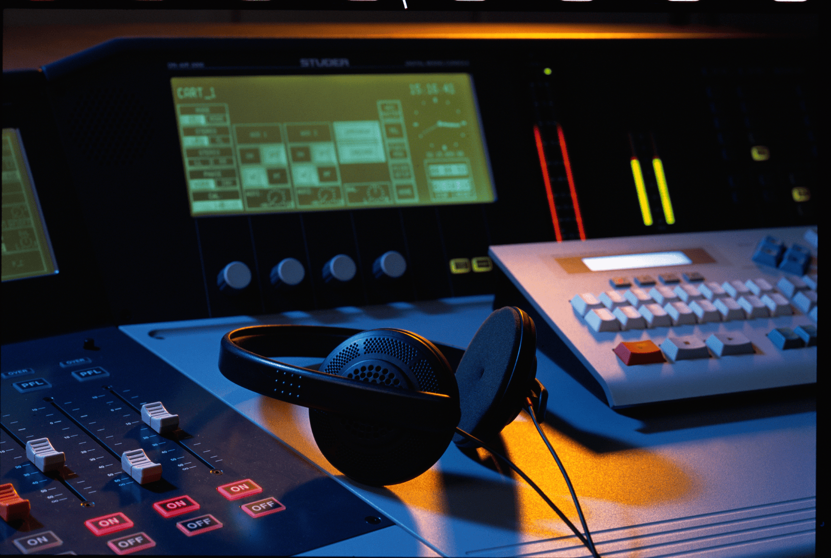 High-quality studio gear for music production, including headphones, mixing board, and sound control panels.
