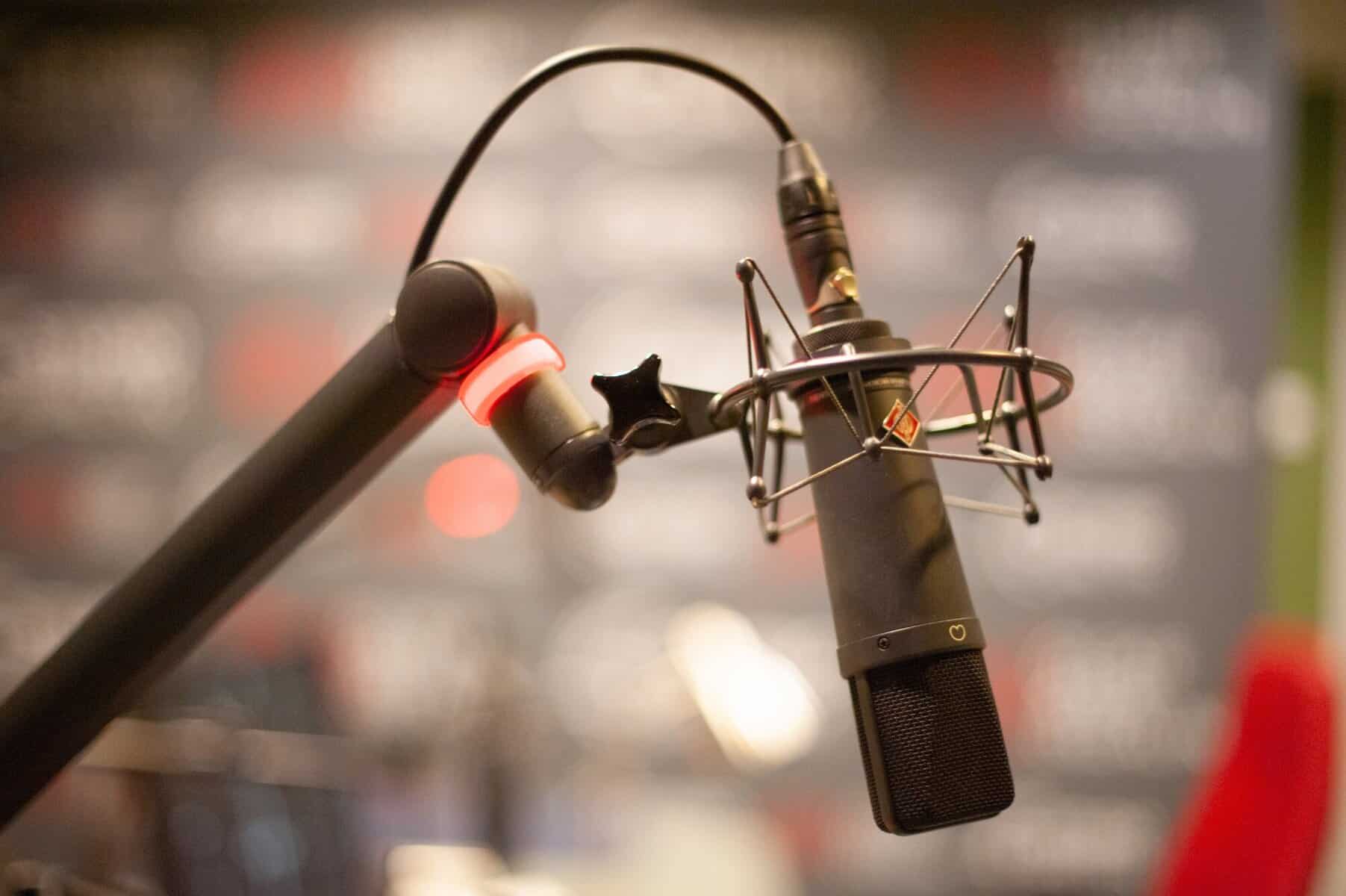 Studio microphone setup, professional recording equipment for podcasting or broadcasting, high-quality mic with shock mount and pop filter.