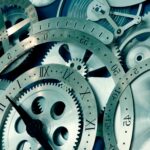 Vintage clock gears, intricate watch mechanism, timepiece engineering, precision gears, mechanical watch parts.